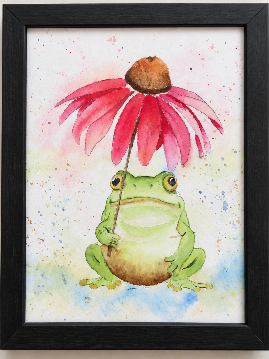 Close-up of Under the Coneflower watercolor art print in a black 8x10 frame, showing a green frog beneath a bright pink flower.