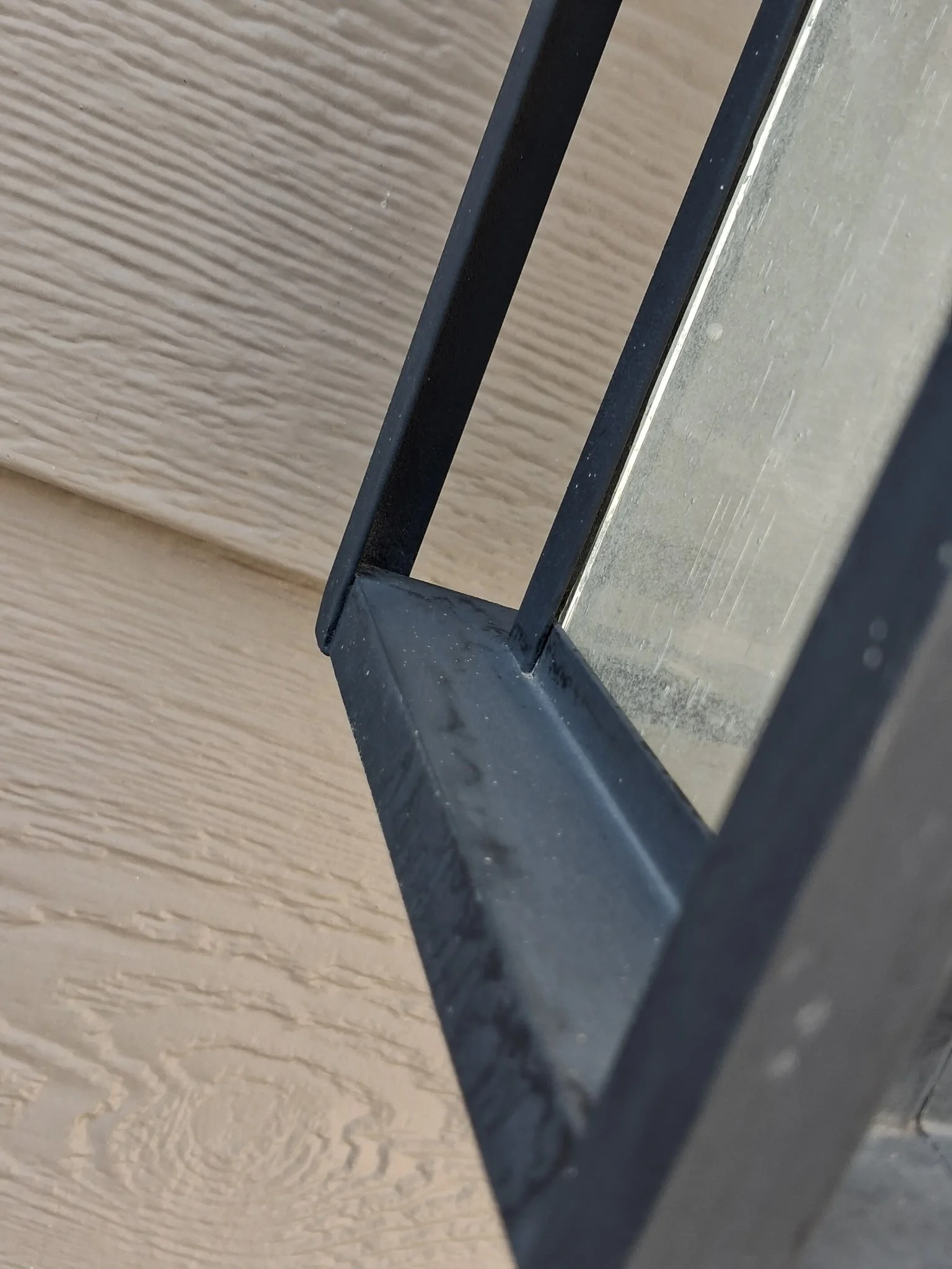 Exterior light fixture after professional cleaning by Reflect Window Cleaning (RWC), showing water spots and residue on the glass and metal surfaces.