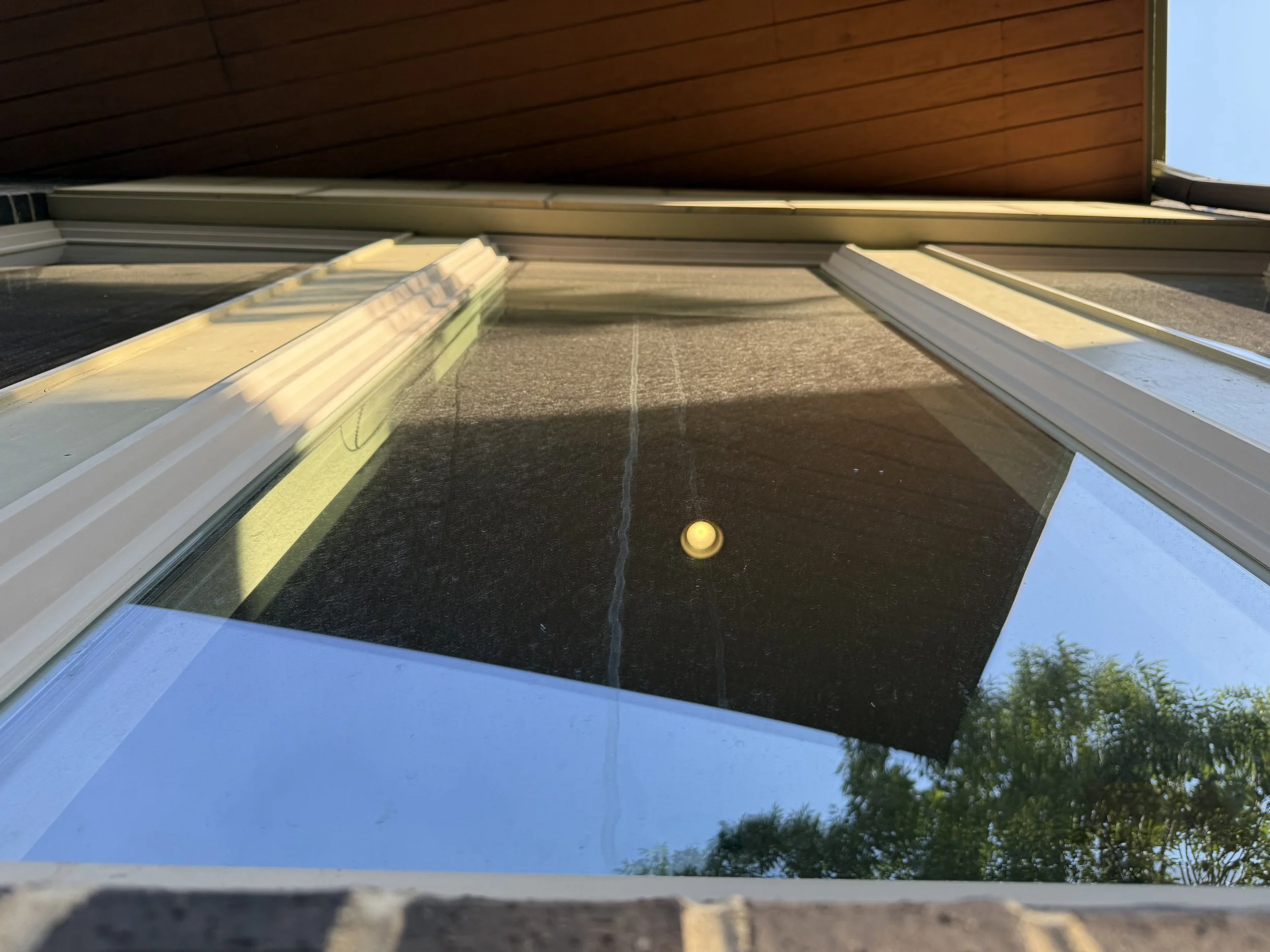 Close-up of residential window glass showing the condition of the exterior surface during an Reflect Window Cleaning RWC window cleaning project.