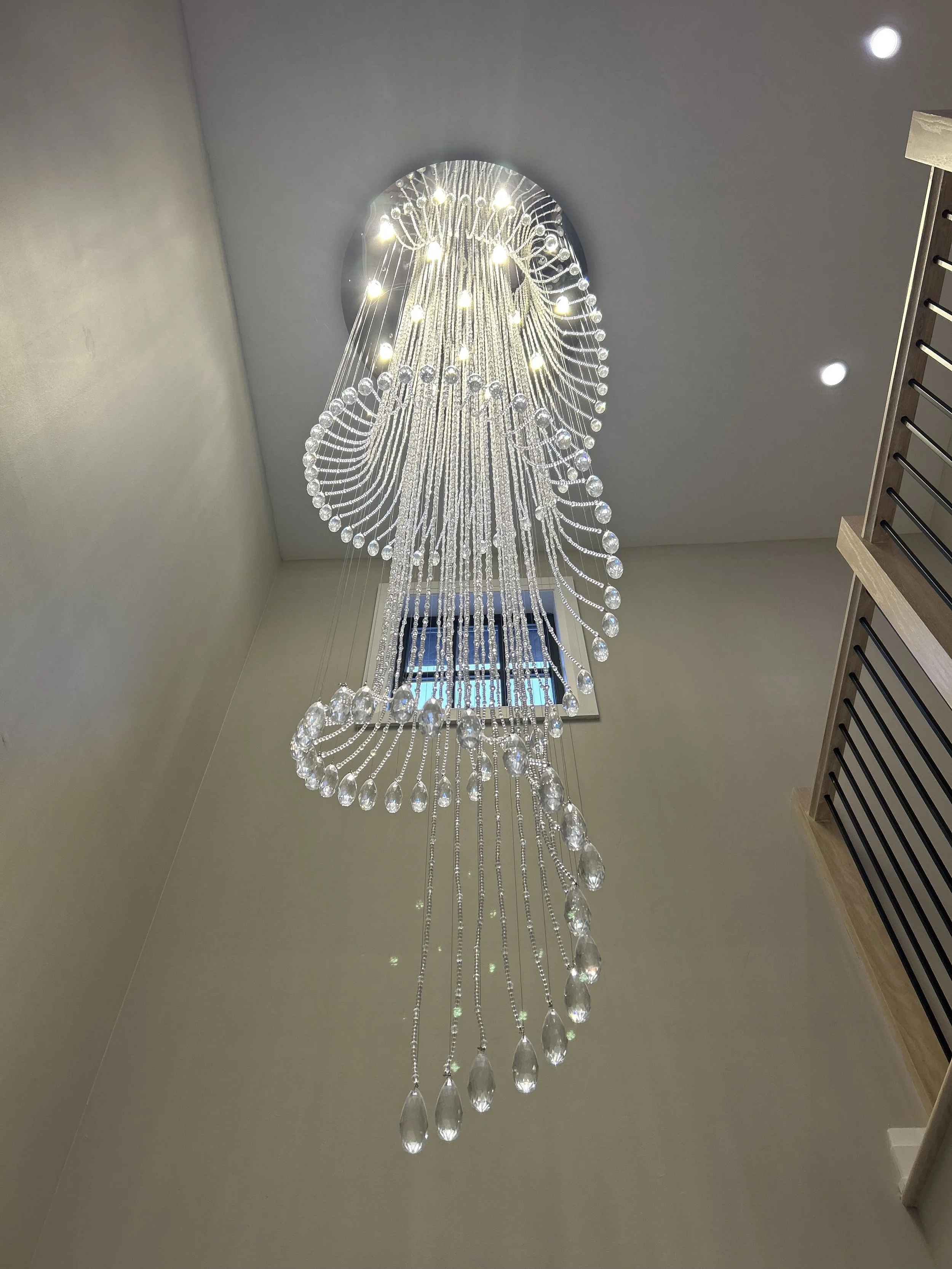 Large crystal chandelier professionally cleaned and detailed by Reflect Window Cleaning (RWC), including individual crystal and fixture cleaning.