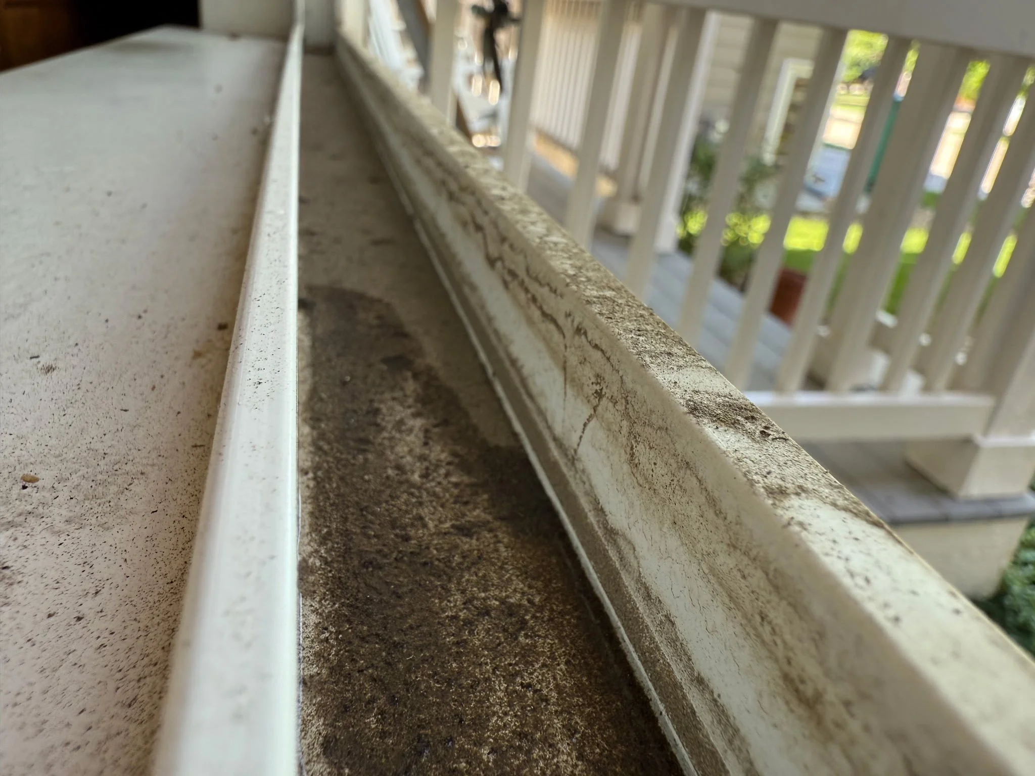 Residential gutter before cleaning by Reflect Window Cleaning (RWC), showing dirt and debris buildup inside the window system.