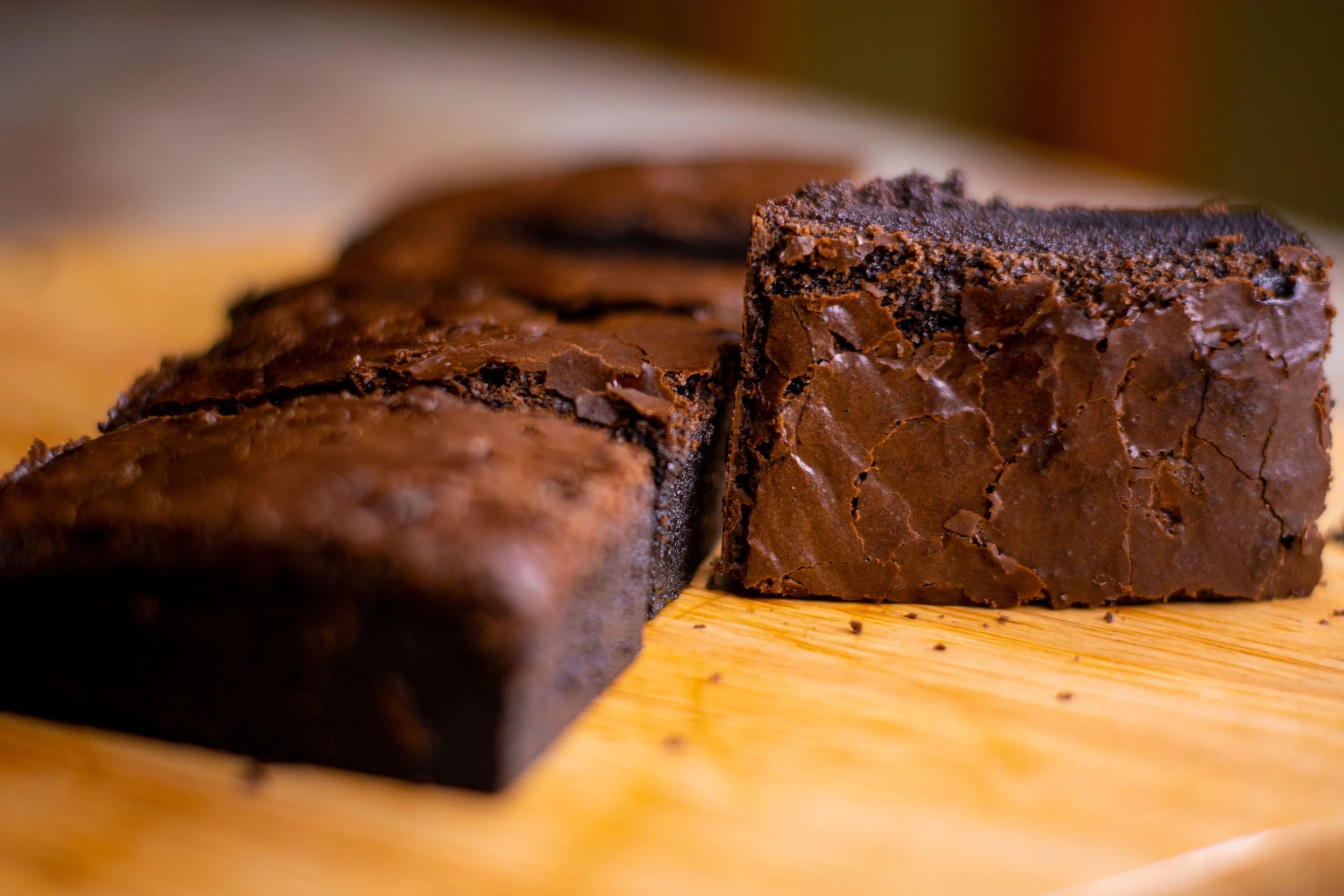 Close-up of a chocolate brownie on a wooden surface.