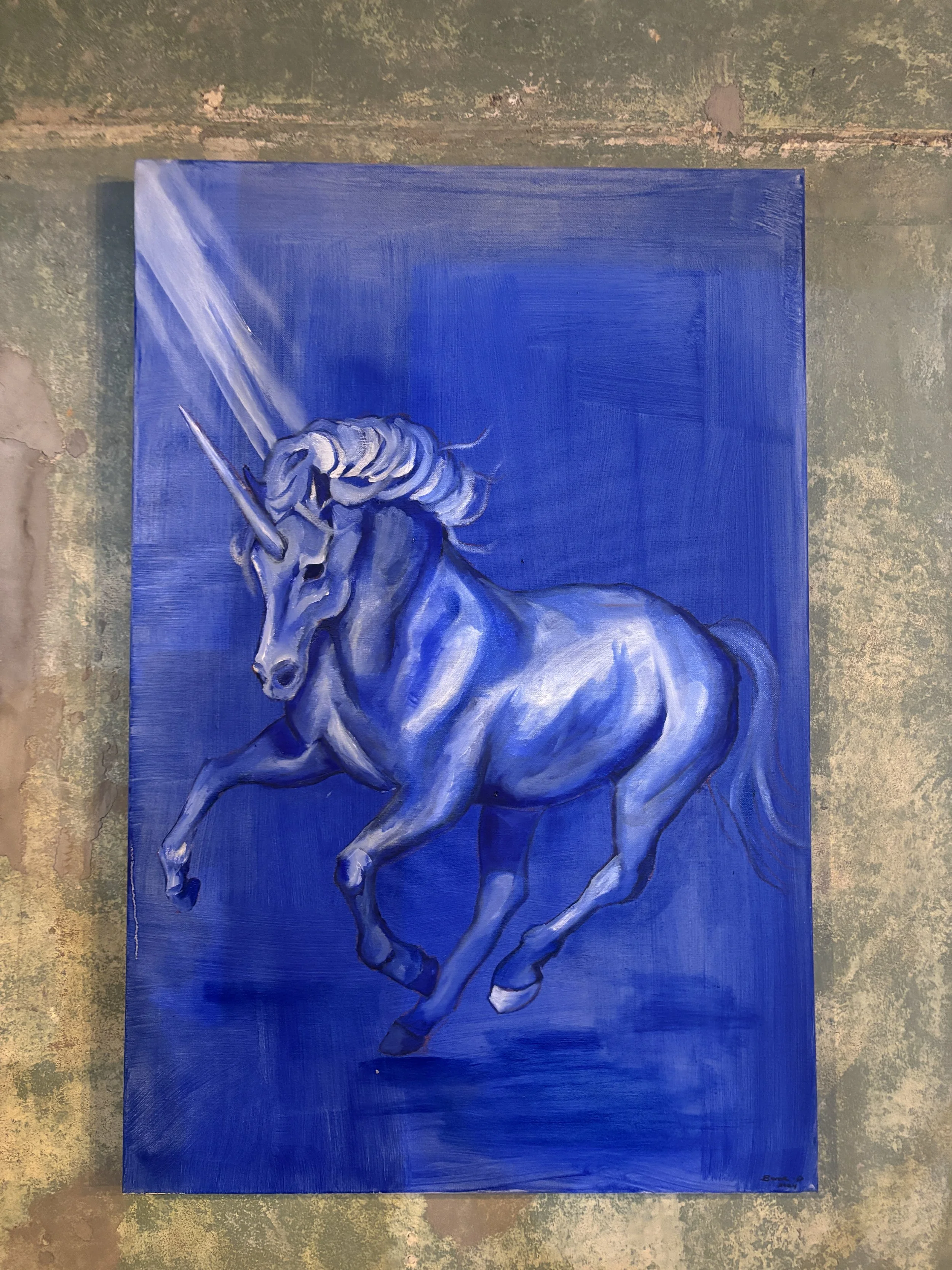 A painting of a white unicorn with a blue background, with the unicorn's head turned to the side and a horn pointing upward.