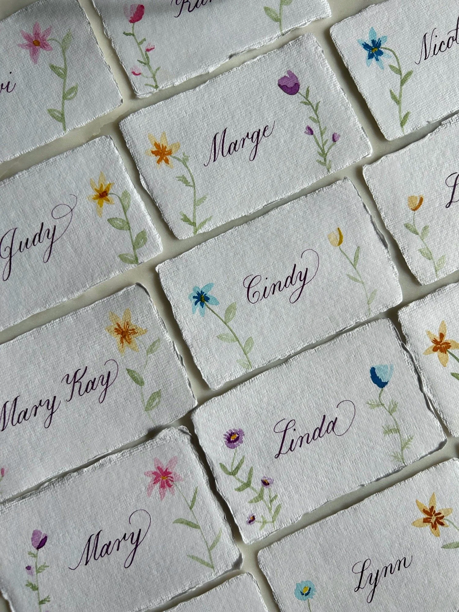 Watercolor place cards in garden party design and calligraphy