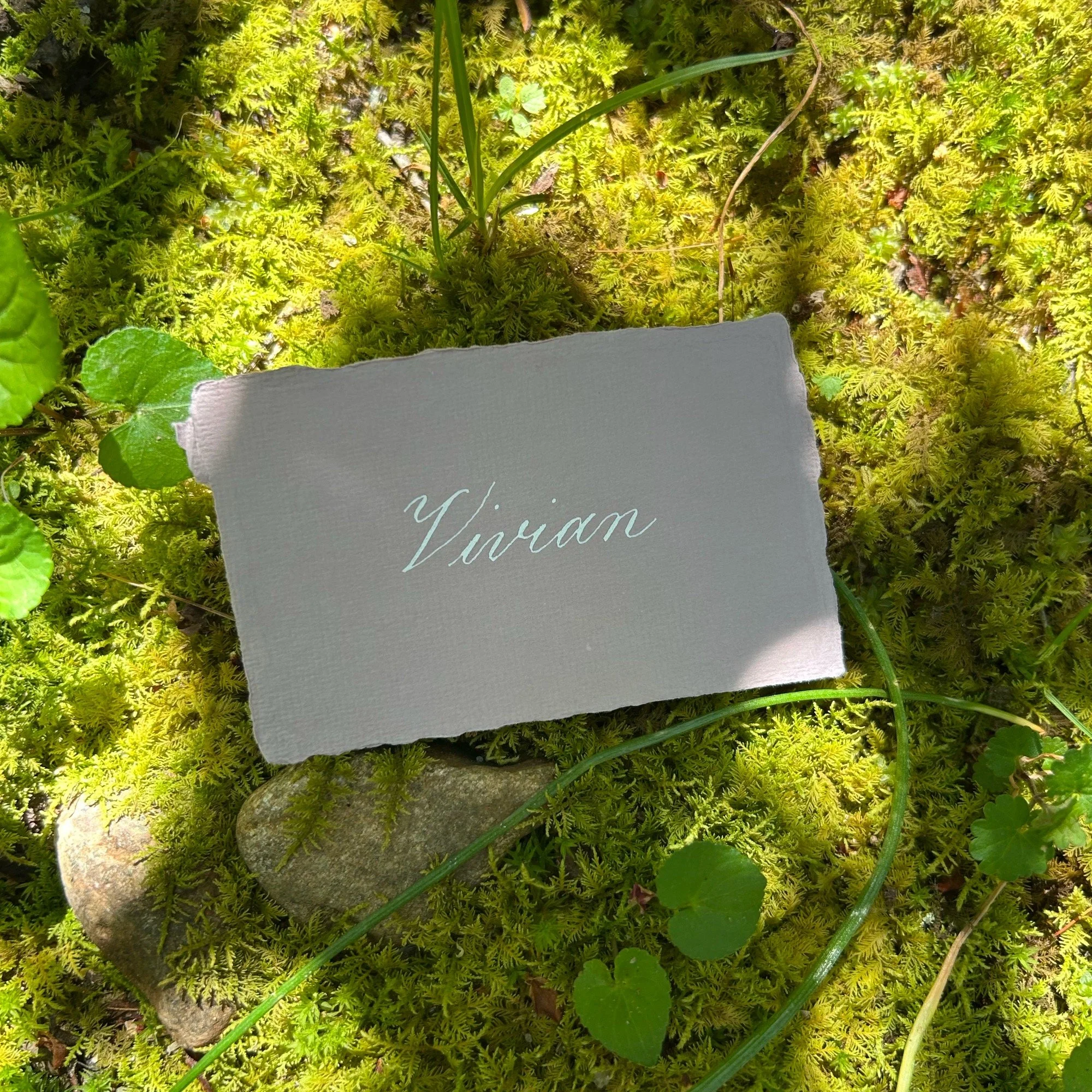 Gray handmade paper place card with white ink calligraphy