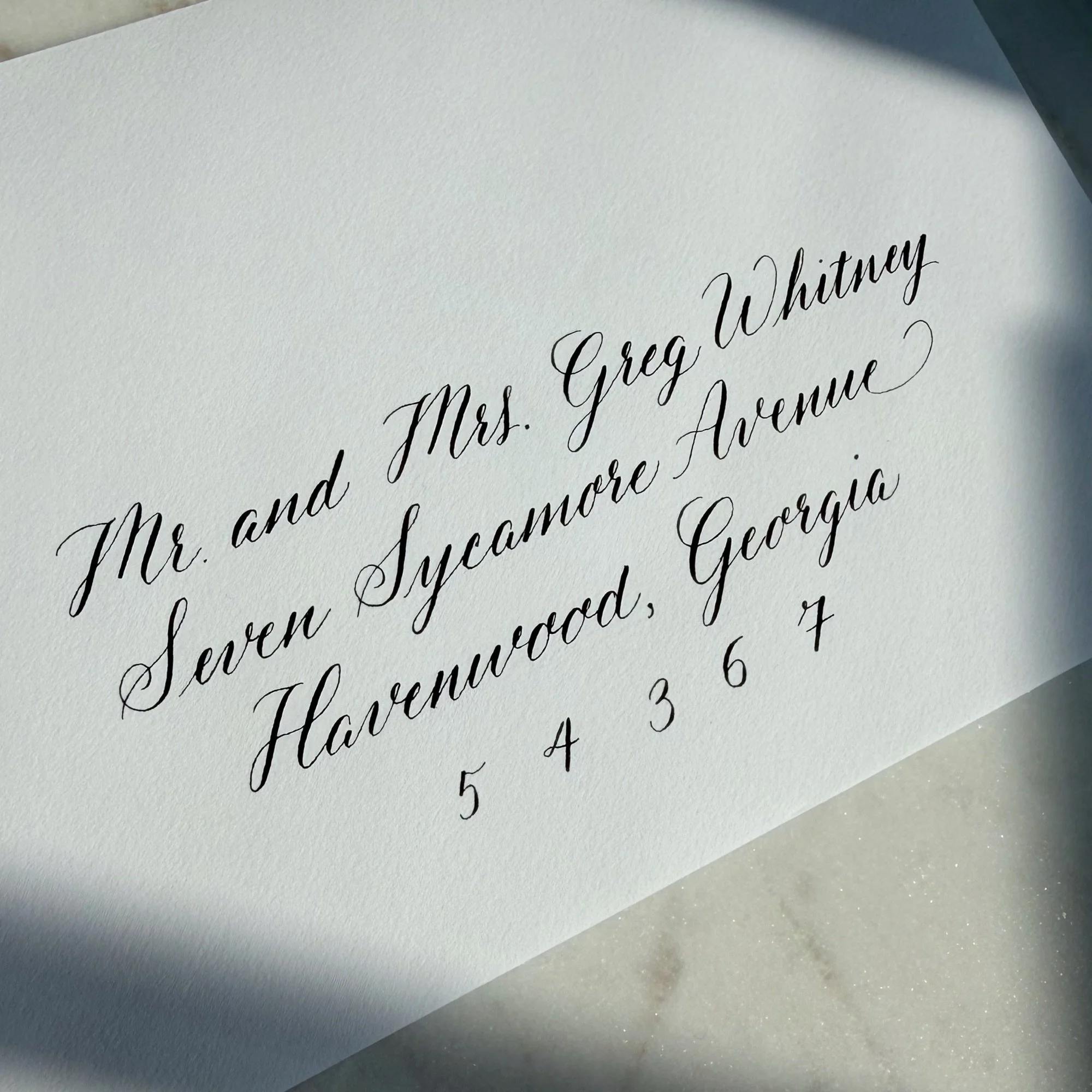 White envelope with handwritten address in calligraphy