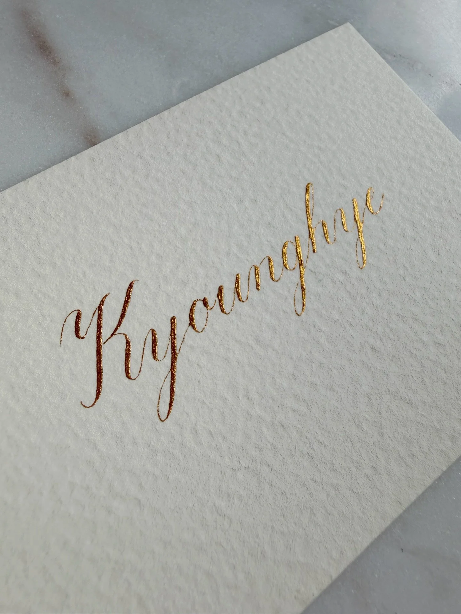 Gold ink Copperplate calligraphy on textured ivory place card