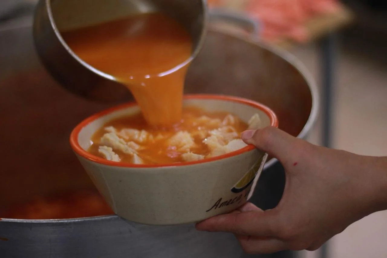 Pouring hot soup into a bowl.