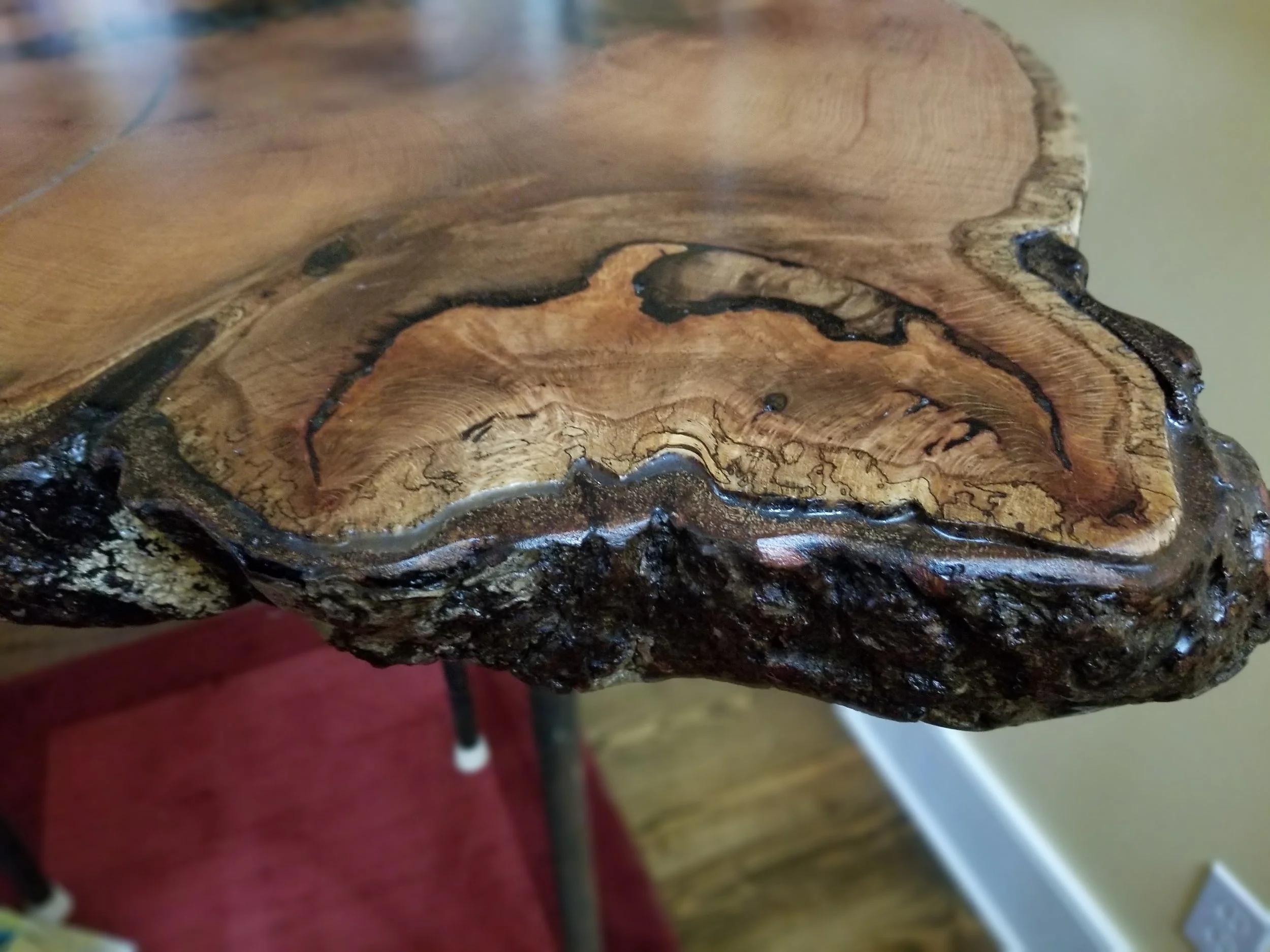 Close-up of a piece of natural wood with intricate grain patterns and a glossy finish.