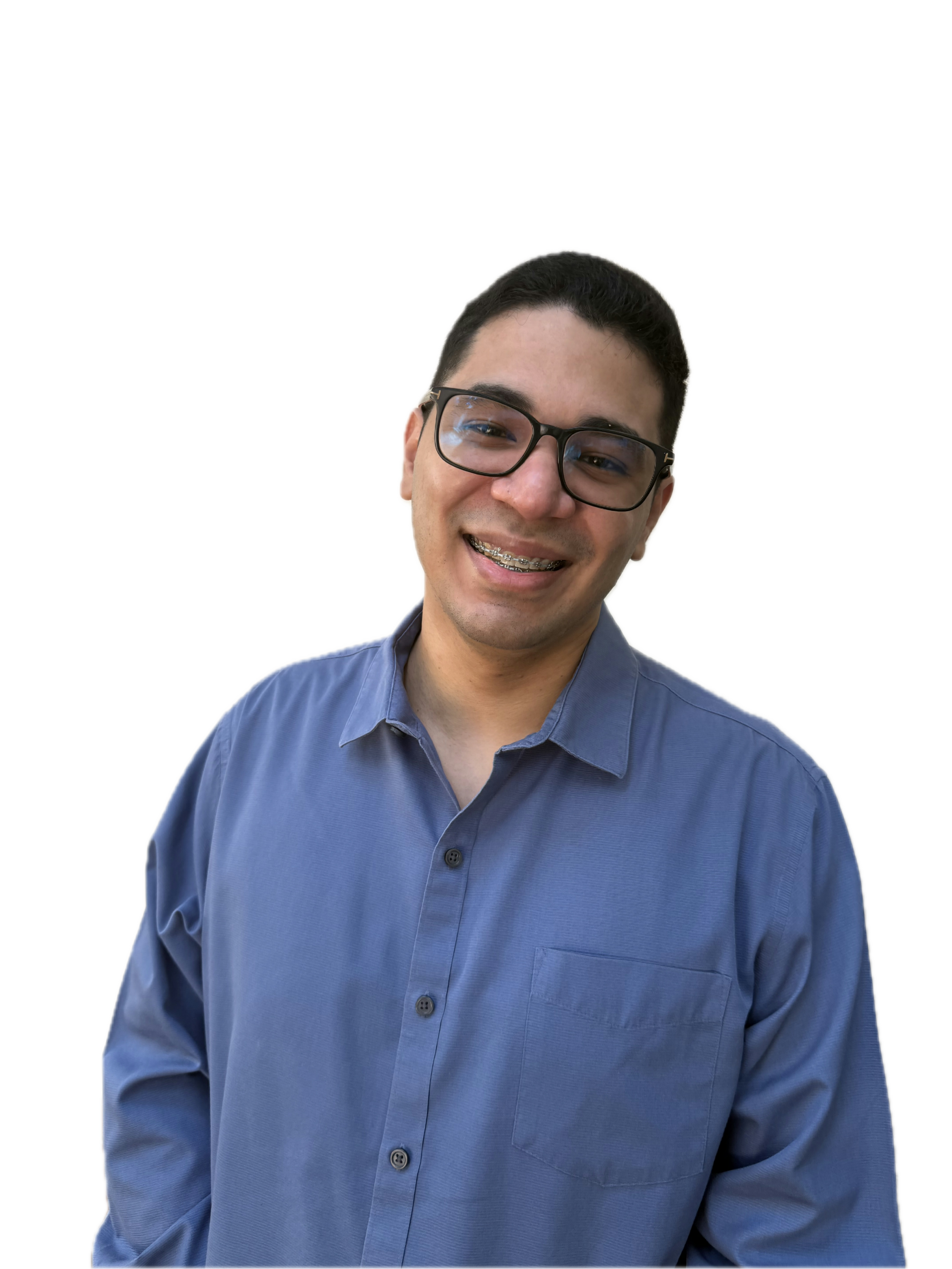 Jorge Pineda, psicólogo de honduras con cabello corto de color negro, usa gafas y una camisa azul de botones, sonríe hacia a la cámara.