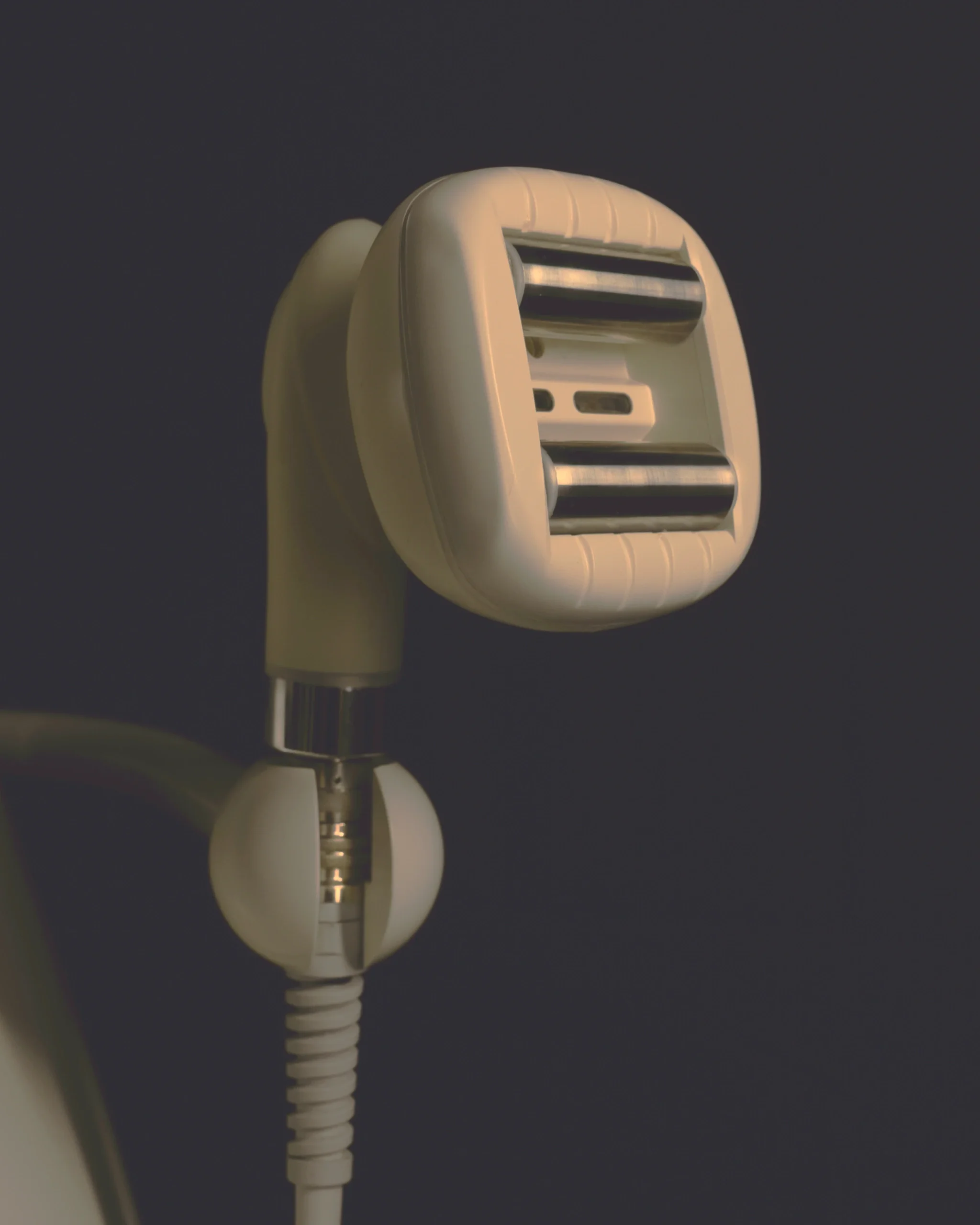 Close-up of handheld TShape2 device against a dark background