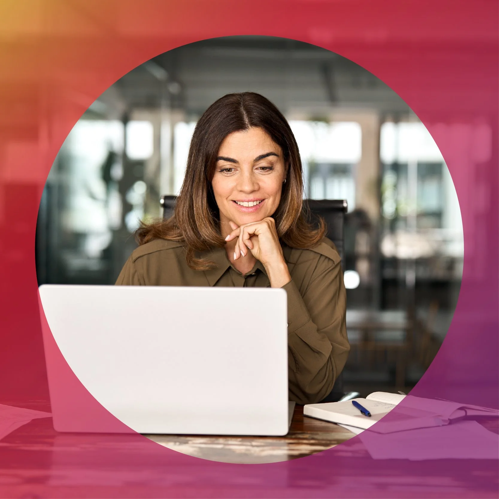 Woman smiling and using a laptop in an office setting