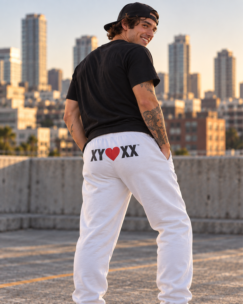 Male model wearing white Sweatpants with the large XY heart XX rear logo