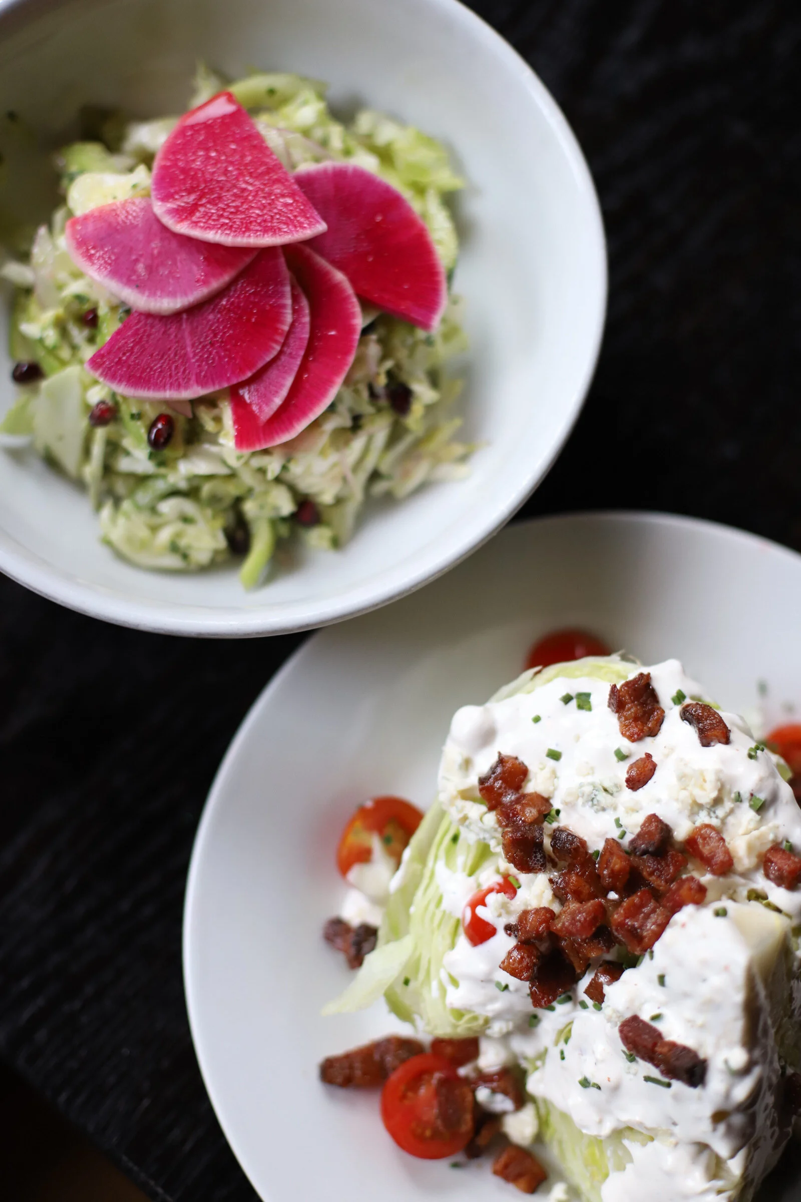 Salad with radish slices, cherry tomatoes, chopped bacon, and a creamy dressing on lettuce