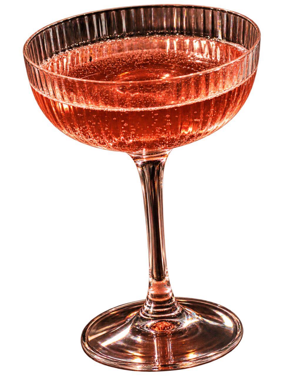 A pink sparkling cocktail in a vintage-style coupe glass with a decorative ribbed pattern around the rim.