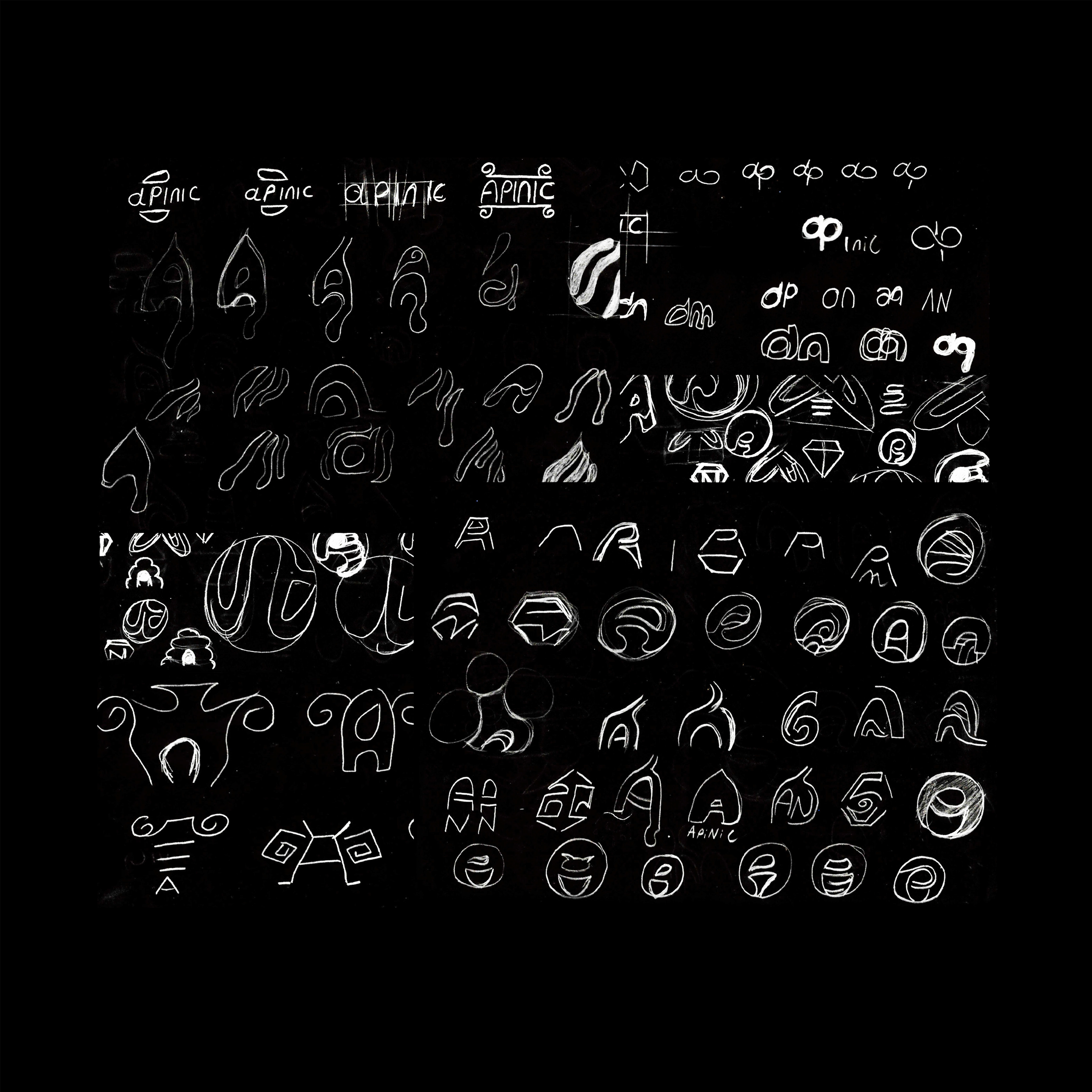 A chalkboard filled with sketches of various abstract symbols, shapes, and lettering designs in white chalk.