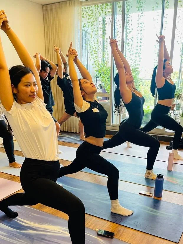 Class in crescent lunge, arms raised together