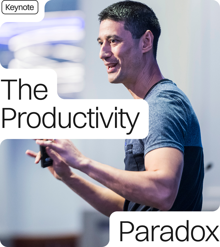 Daniel Sih presents to a room. He wears a light blue top. The text reads 'The Productivity Paradox Keynote'