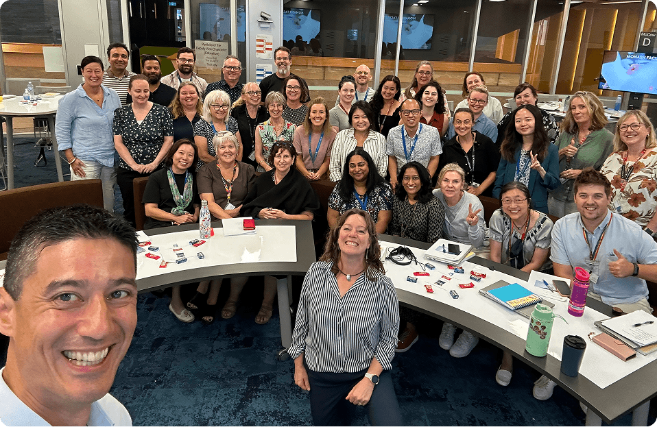 Daniel taking a selfie with a team of 40 people in an office