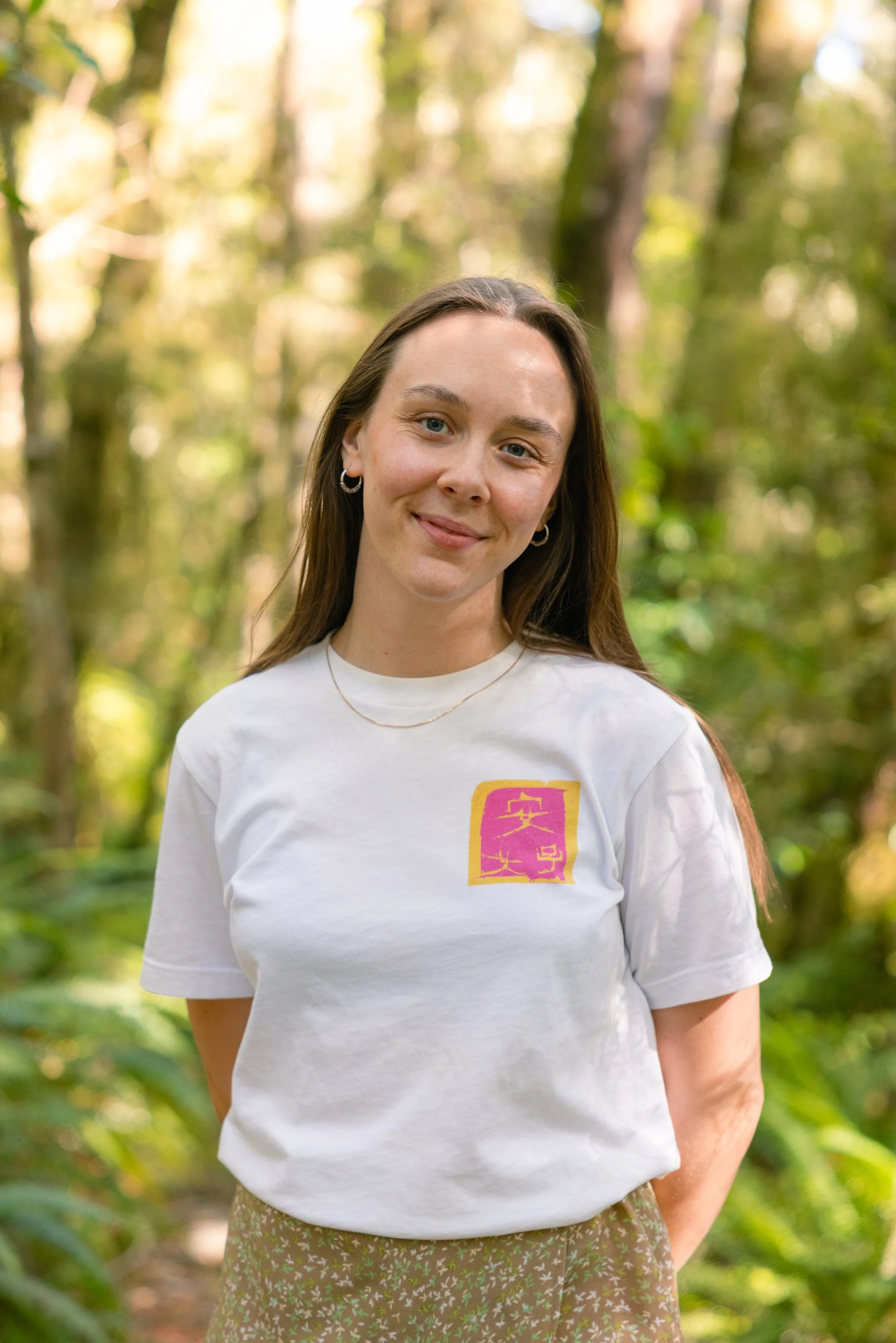 Photo of Ella Stanton-Warren, director and founder of Move With Ella, standing smiling in a garden setting.