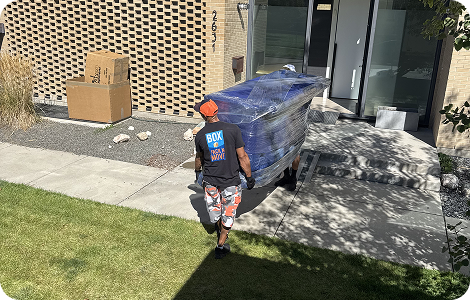 Residential mover carrying wrapped furniture