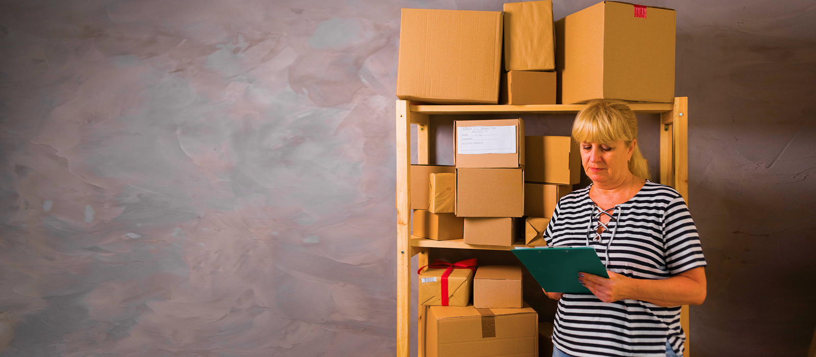 Woman reviewing moving documents beside packed boxes