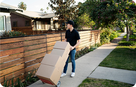 Movers transporting stacked household boxes