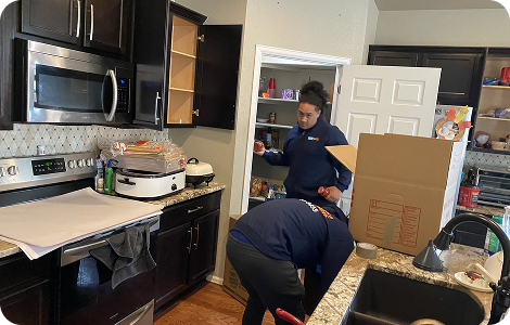 Residential movers packing kitchen belongings
