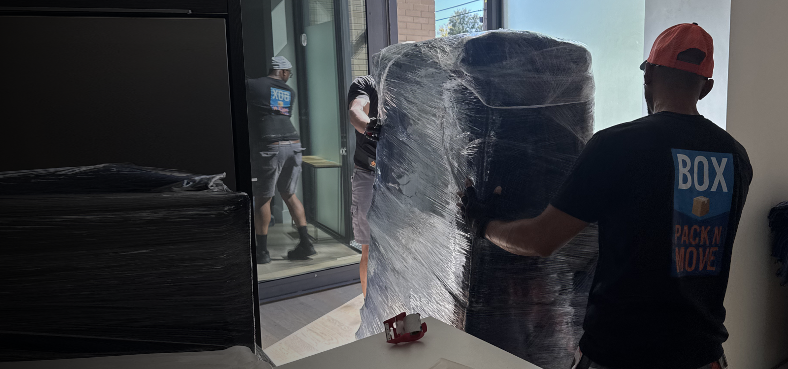 Professional movers transporting a heavy gun safe.