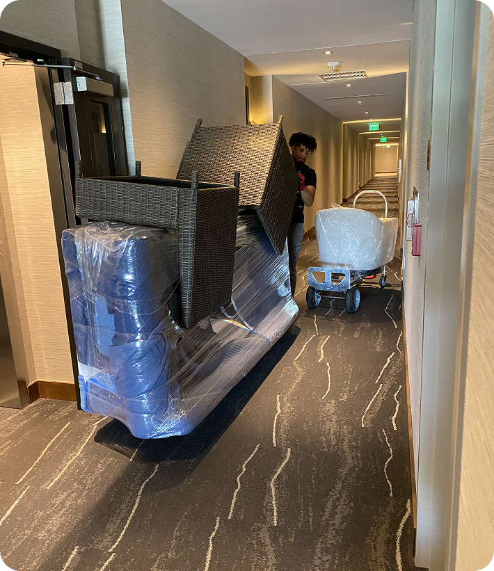 Furniture movers handling large wrapped items