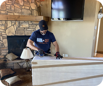 Senior moving crew positioning a wooden cabinet