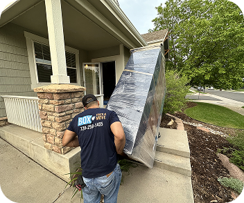 Furniture and appliance moving services, movers carrying a wrapped item