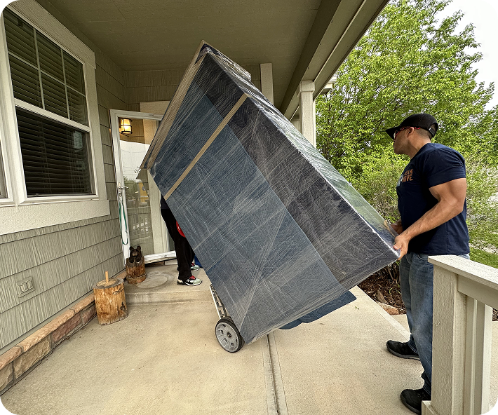 Residential movers carrying wrapped furniture