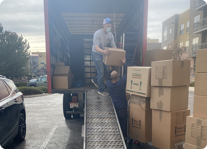 Residential movers loading household boxes into a truck