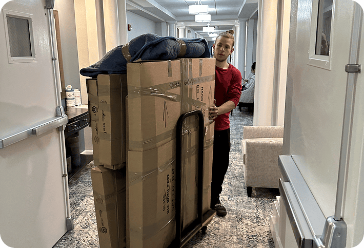 Professional mover transporting packed boxes on a dolly