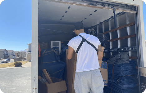 Mover loading household items into a moving container