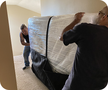 Movers handling a large wrapped item