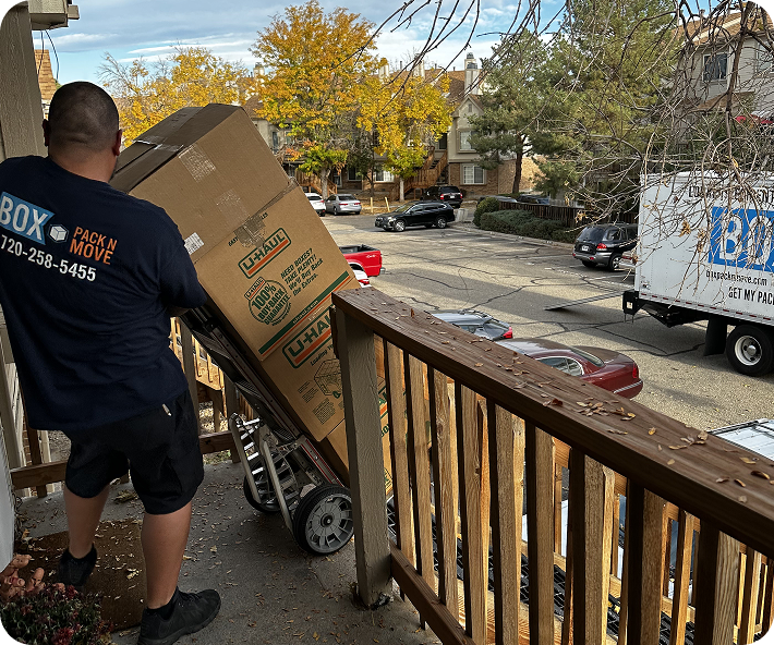 Long distance movers loading boxes onto a dolly