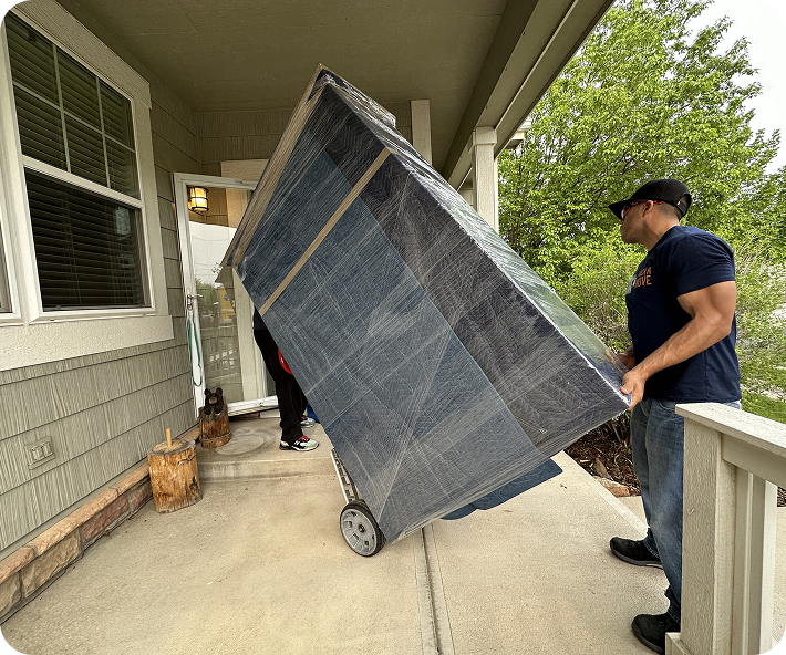 Residential movers handling wrapped furniture
