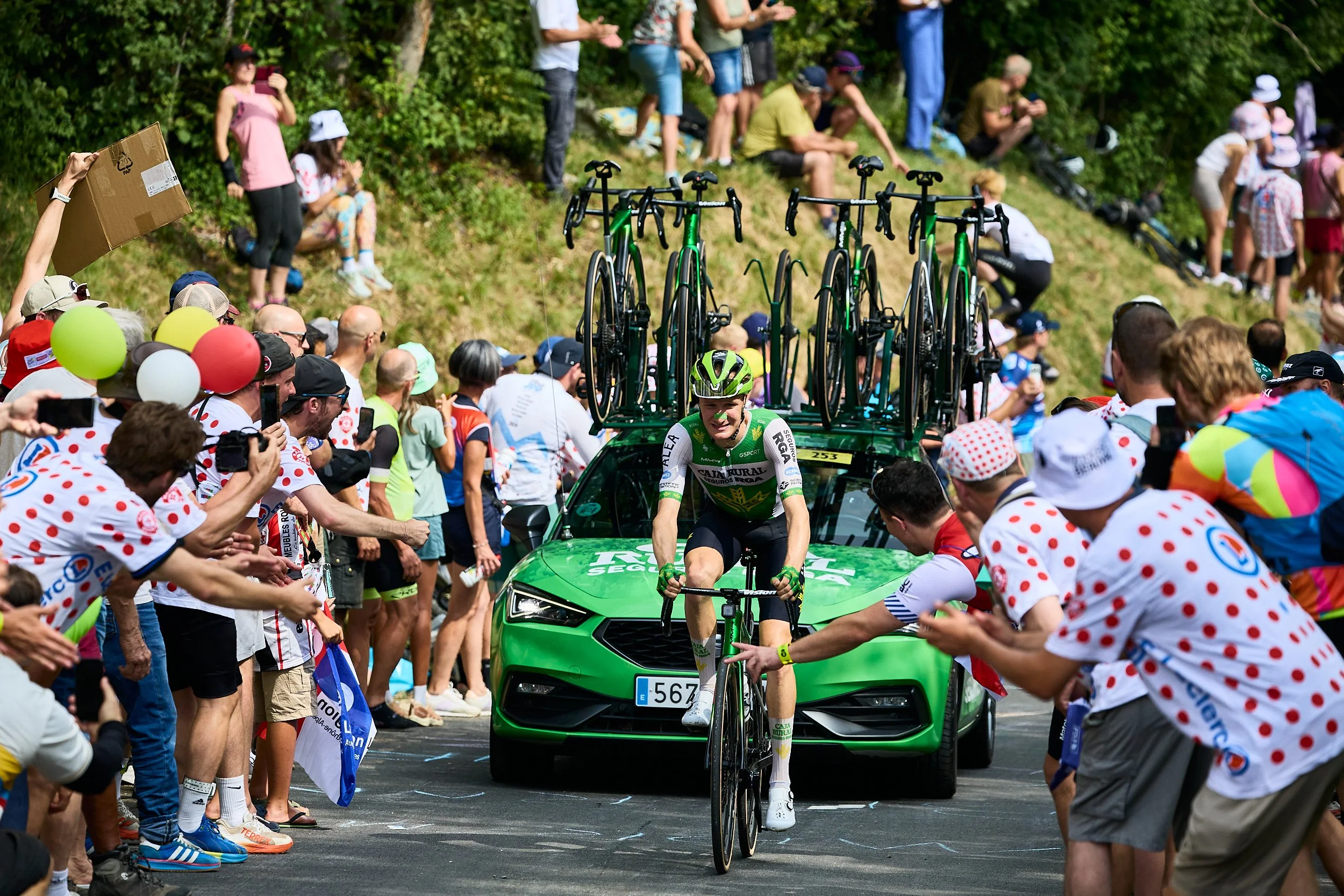 Coureur seul devant sa voiture au milieu de la foule. Tour de France 2026