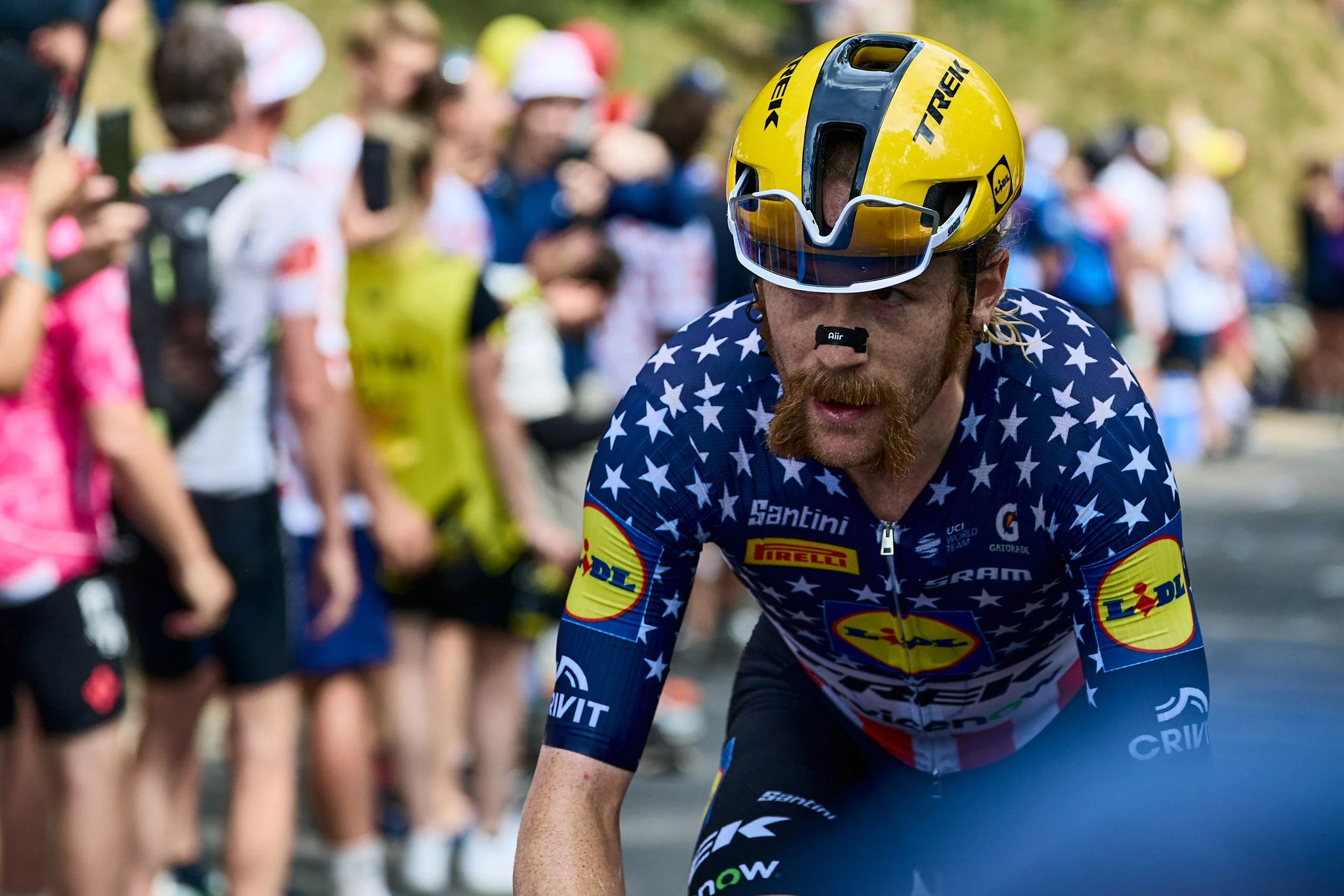 Portrait d'un coureur au maillot étoilé en pleine ascension, Tour de France 2026 @Queen SIMONS