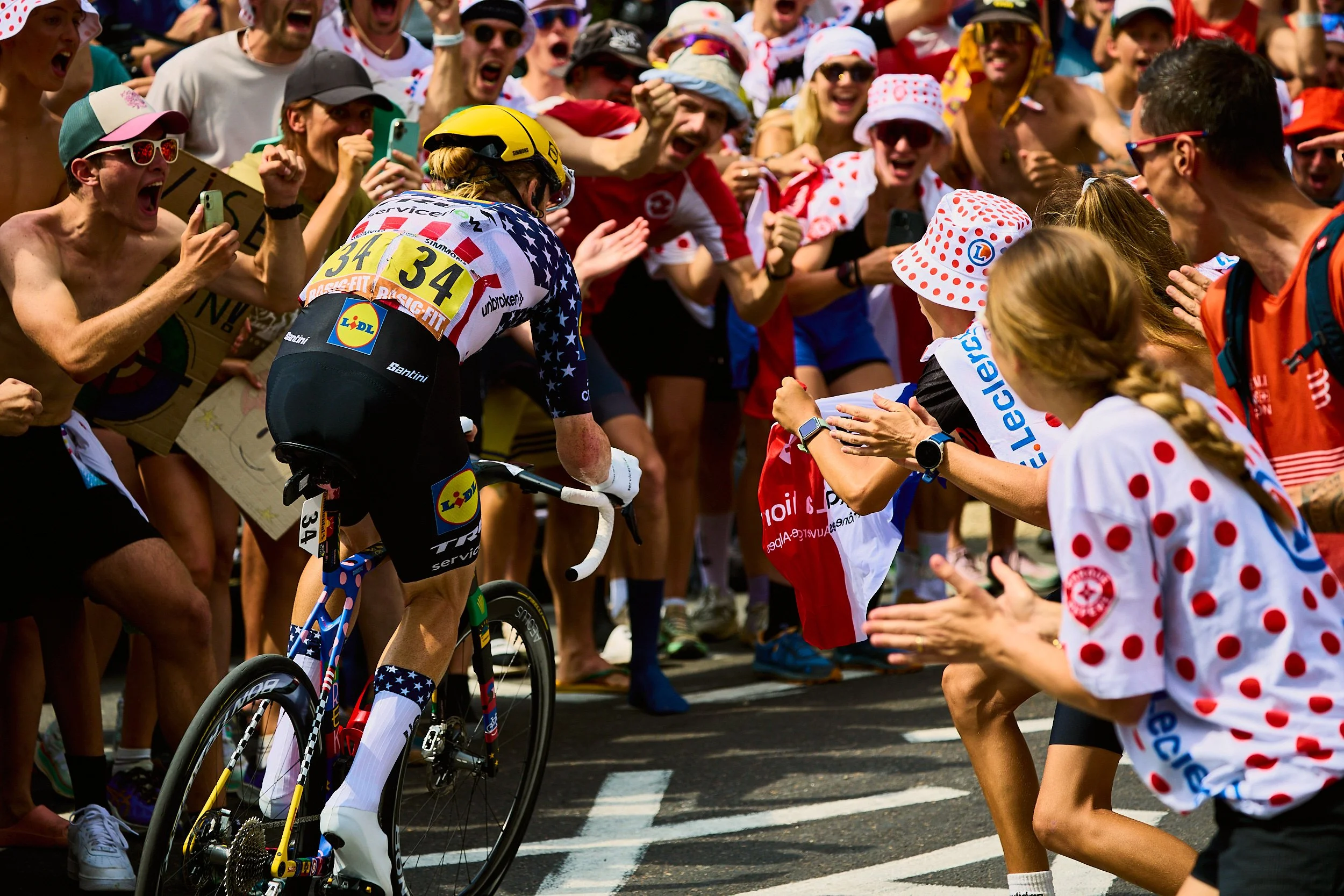 Coureur vu de dos au milieu des spectateurs en maillot à pois, Tour de France 2026 @Queen SIMONS