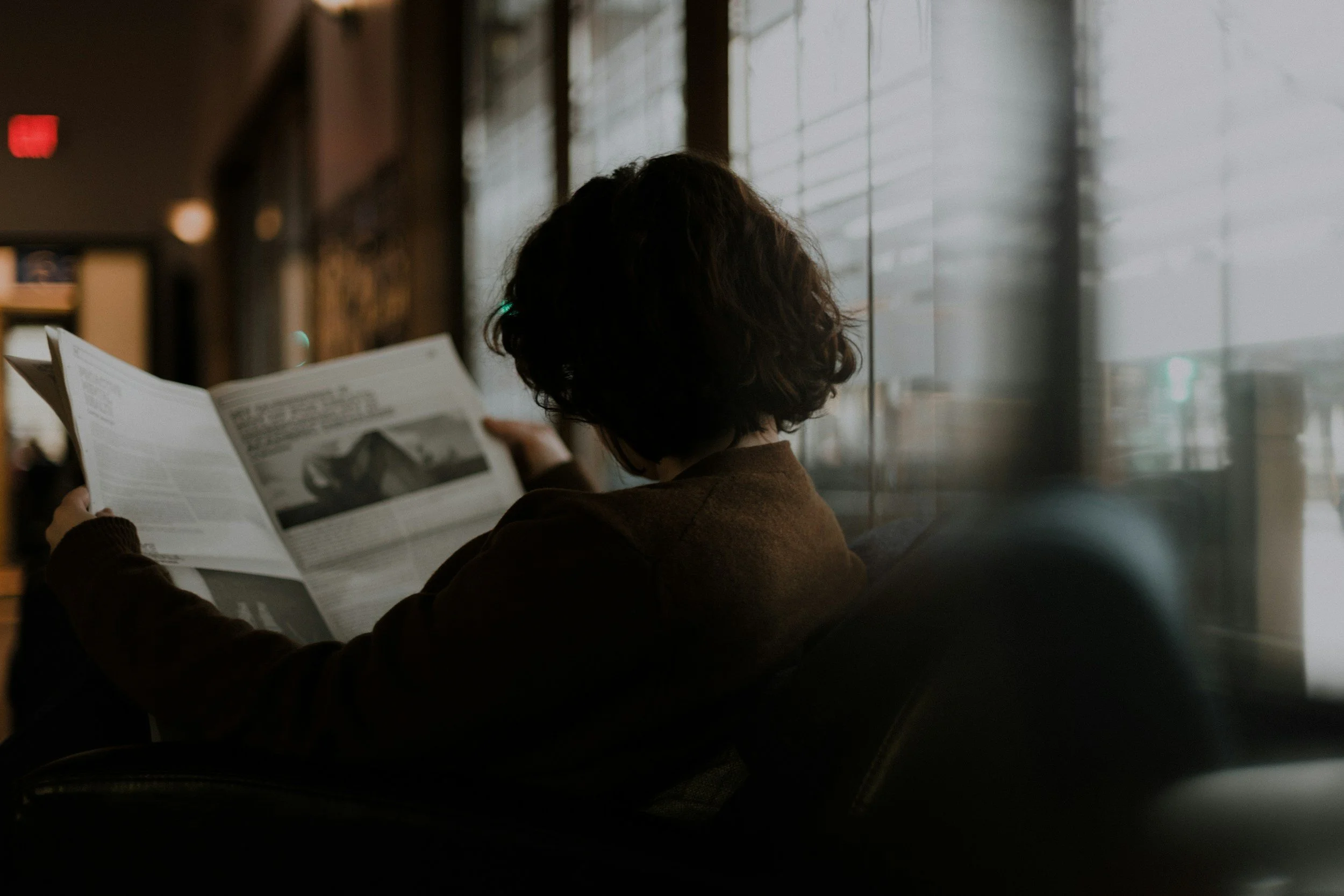 Person reading a magazine, representing HAELM's close reading of advertising