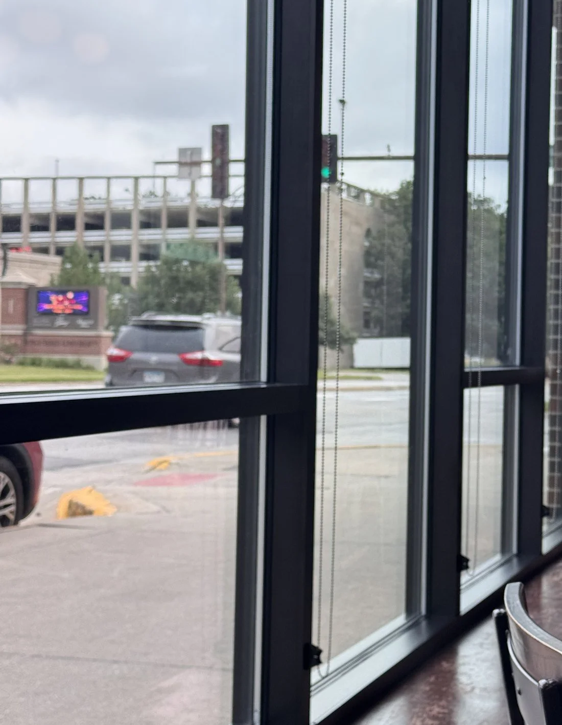 A quiet window seat in a café, looking out at the street on a grey afternoon.