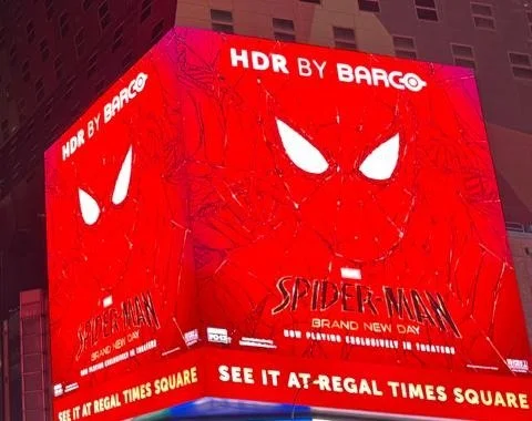 Close-up of the Spider-Man: Brand New Day building takeover in Times Square showing the 'HDR by Barco' attribution line