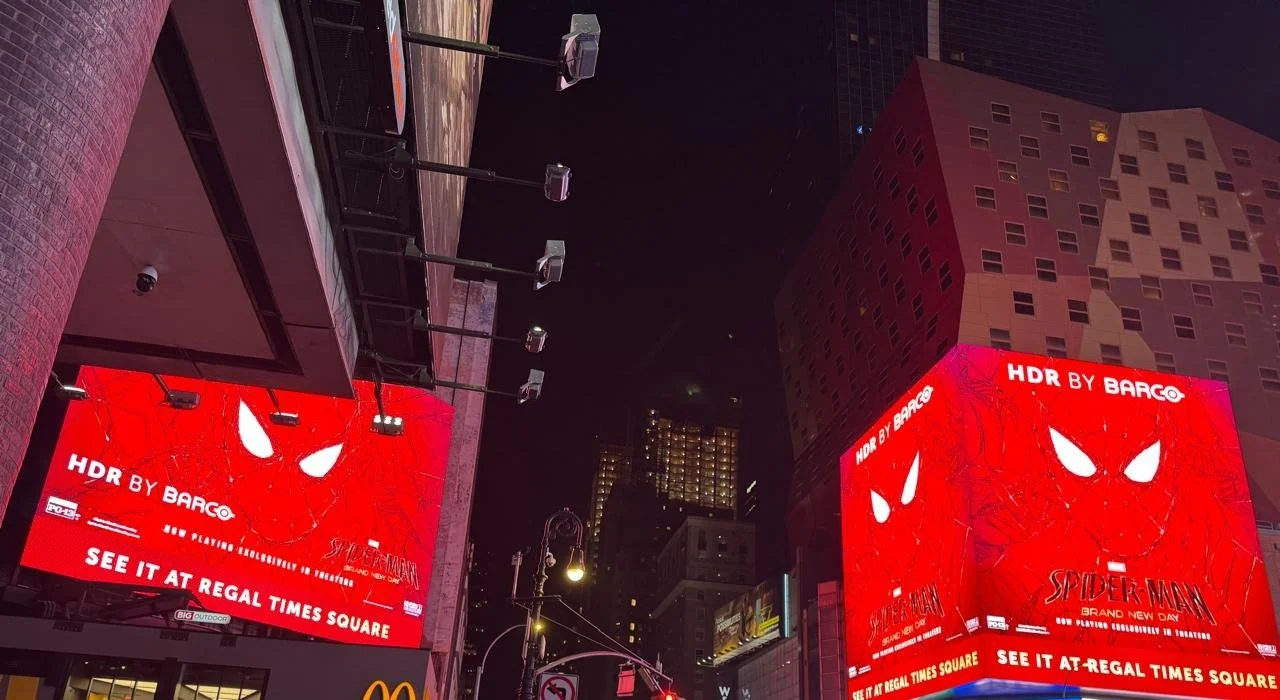 Low-angle view of the Times Square billboard structure and surrounding towers at night during the Spider-Man: Brand New Day takeover