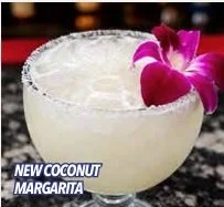 Copa de margarita de coco con flor rosa como decoración.