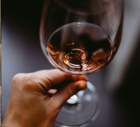 Person holding a glass of rosé wine