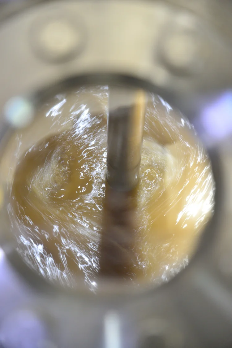 Agitated fermentation broth seen through the sight glass of a bioreactor