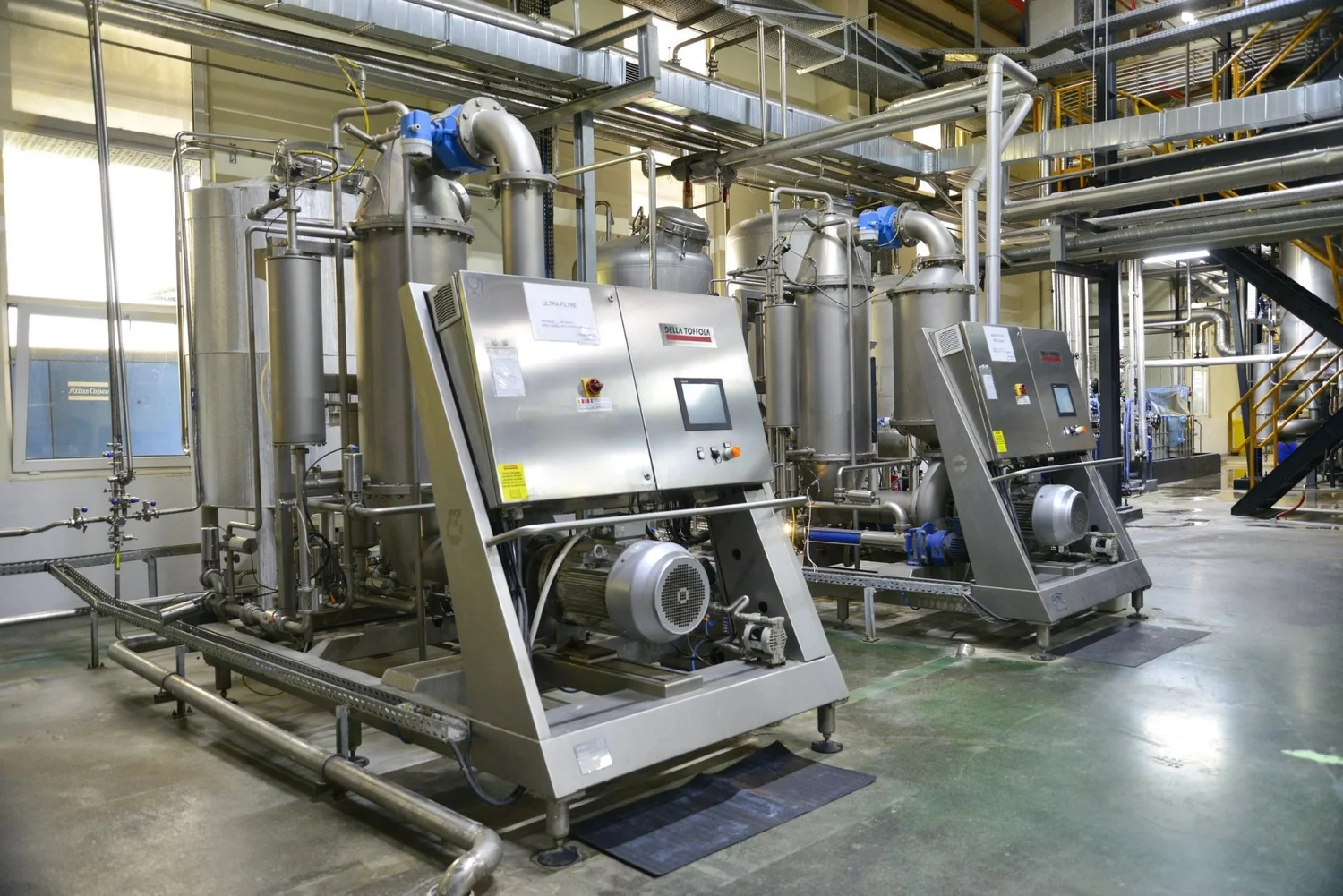 Two stainless steel skid-mounted processing units with control panels in Livzym's downstream processing plant
